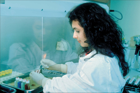 Lab technician working under a fume hood