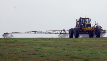 Tractor spraying chemicals on pasture