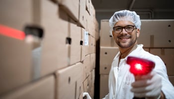 Factory worker with hairnet holding bar code scanner