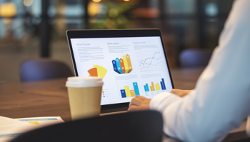 Close up of businessman using a laptop with graphs and charts on a laptop computer