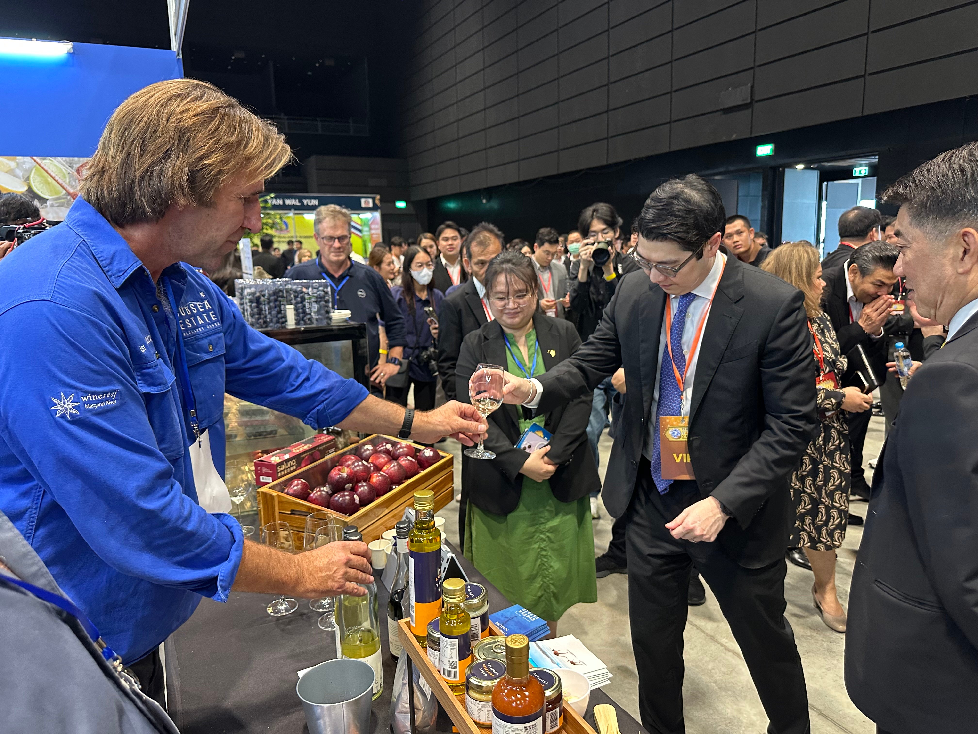 A wine exporter providing a tasting to a Japanese government official at an exhibition stand 
