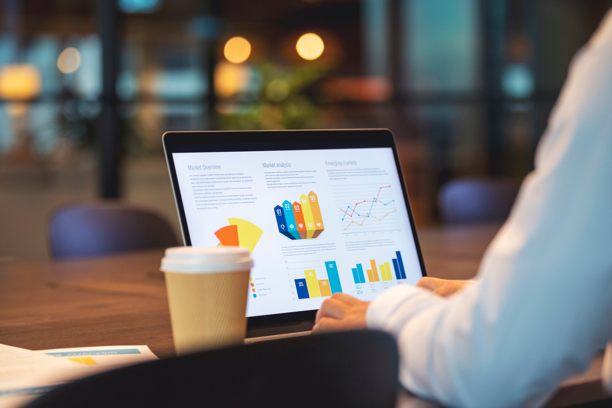 Close up of businessman using a laptop with graphs and charts on a laptop computer