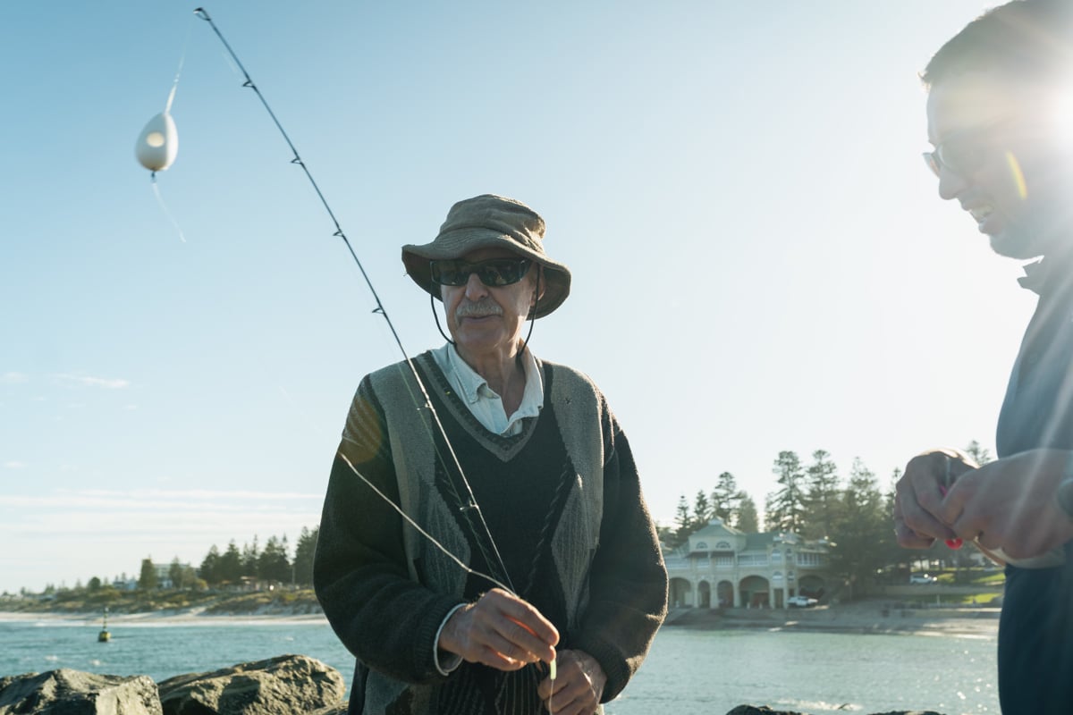 Close-up image of a fisherman holding a fishing rod at Cottesloe beach