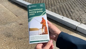 Image of person holding recreational fishing guide brochure