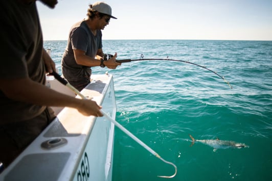 Two people fishing on a commercial fishing charter