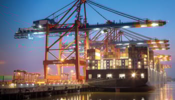 Container ship being loaded at night in port