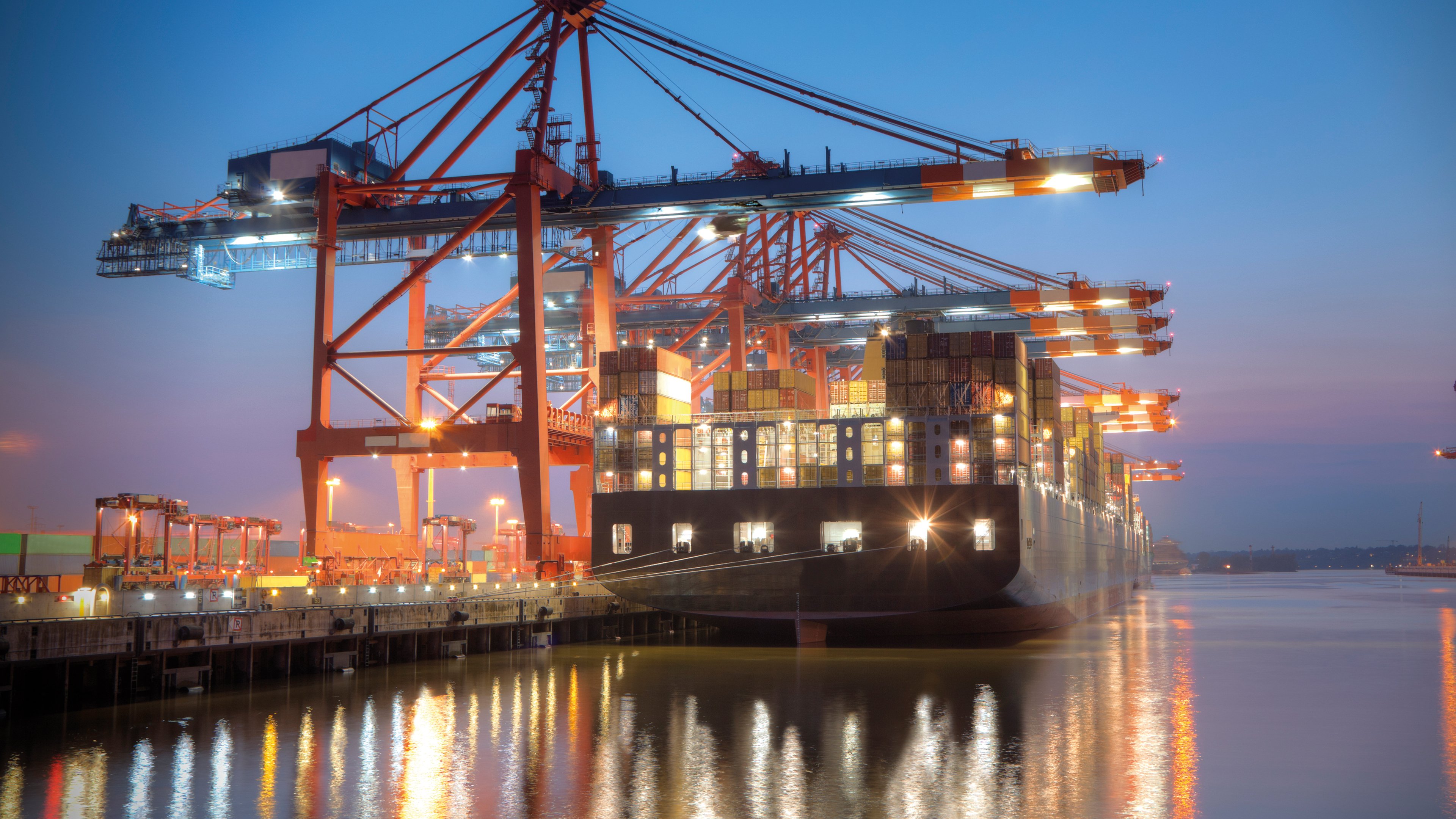 Container ship being loaded at night in port